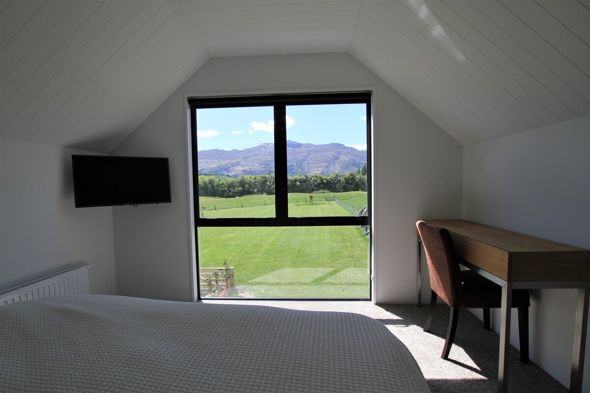 Master Queen size bed and duvet with electric blanket.  TV, central heating and writing desk.  Behind is a full length mirror, hanging rack and shelves.  there are robes in the wardrobe.  Bedside lights, clock/radio. Nice spacious room with a view!