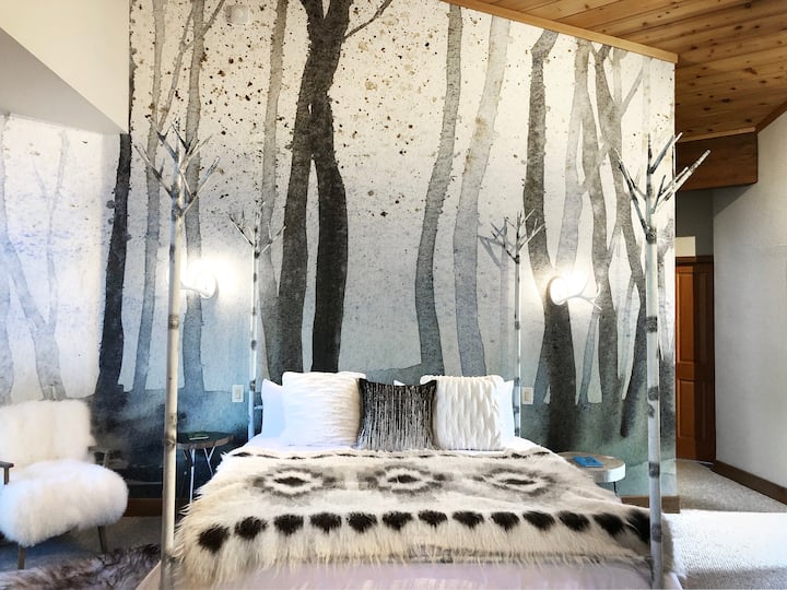 The spacious 2nd floor Enchanted Forest loft space area features a king bed and access to a private outdoor deck overlooking the creek, a reading nook, and access to the hall jack-and-jill bathroom. 