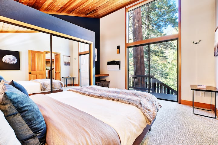 Lower  bedroom with views of the forest and deck and stairs that lead to hot tub. 