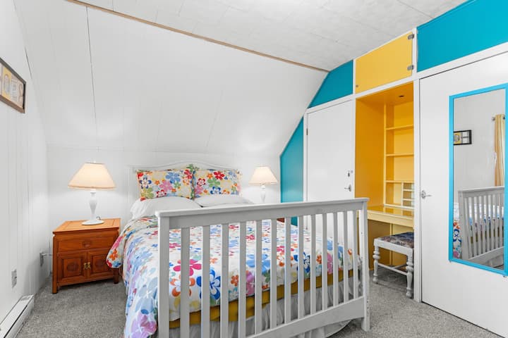 An upstairs bedroom at Whimsy Cottage with a full size bed plus a dedicated space for working from home.