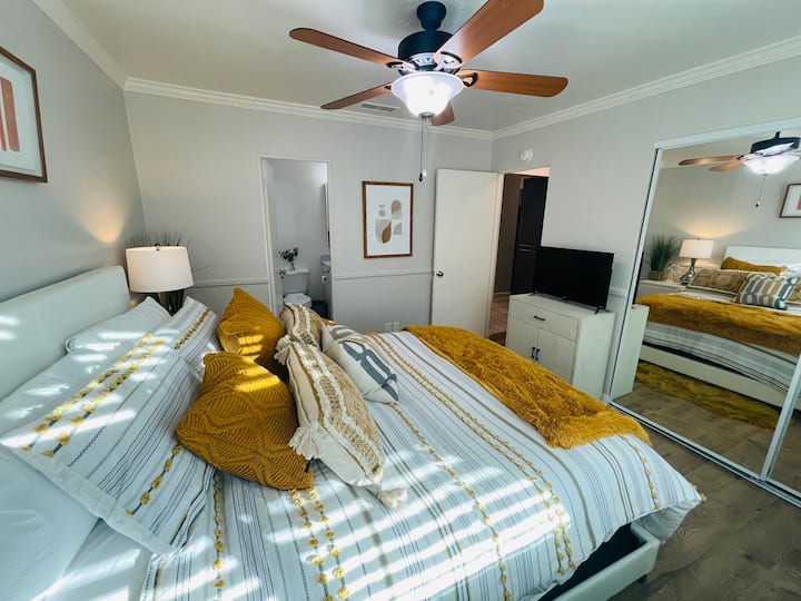 ห้องนอนควีนไซส์และห้องน้ำพร้อมทีวีและตู้เสื้อผ้า