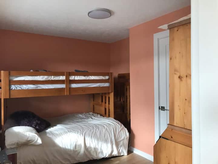 חדר ילדים עם מיטת קווין סייז ורווקה למעלה.