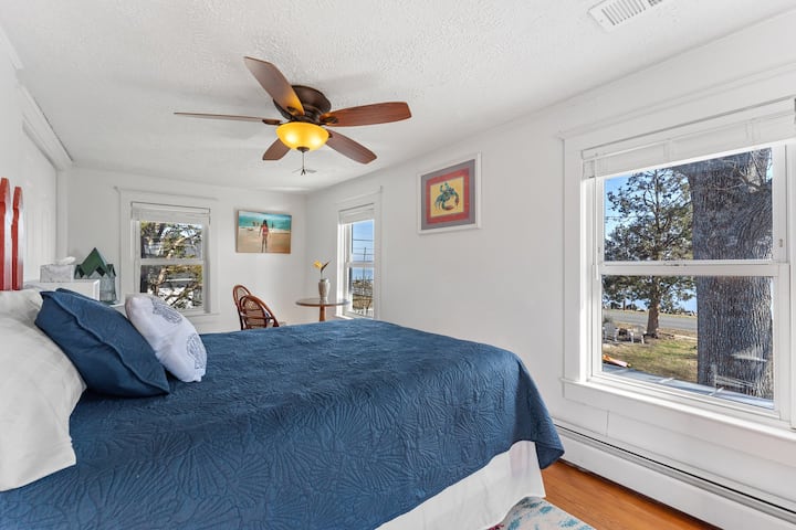 Upstairs bedroom with Queen bed, table and chairs, waterview / sunrise view and TV