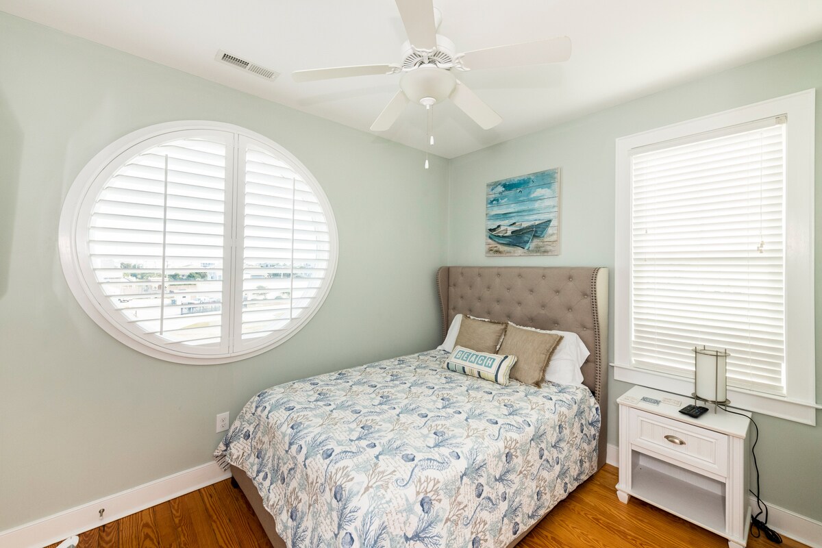 Dormitorio principal con ventana circular, vistas al mar y televisión