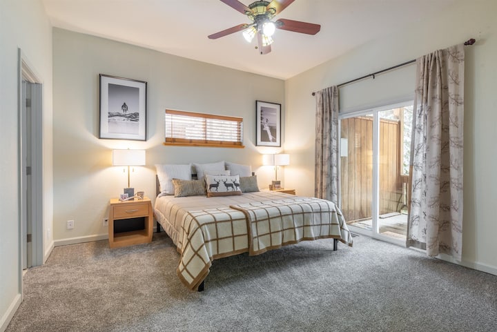 غرفة النوم الرئيسية مع أبواب منزلقة تؤدي إلى السطح الخلفي والإطلالات.