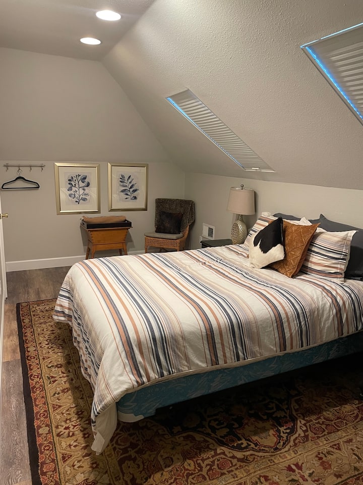 Двойно легло на горния етаж със стол и малко работно пространство на бюрото.