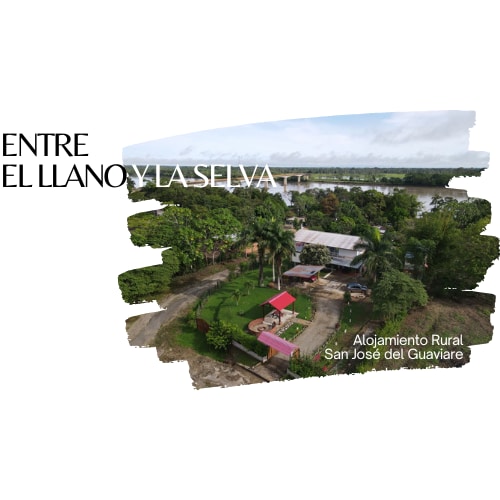 An aerial view captures the property surrounded by lush greenery, with the Guaviare River visible in the background. The outdoor areas include a garden, parking space, and a shaded area with chairs. The house blends into the natural environment, offering a peaceful retreat.