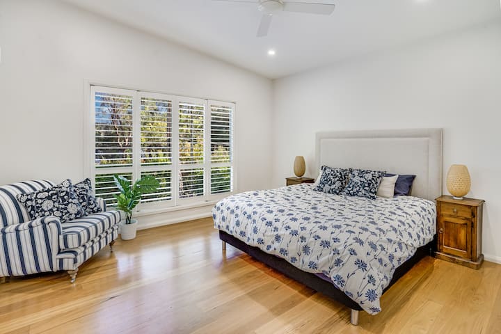 غرفة نوم رئيسية بسرير كبير وخزانة ملابس وحمام داخلي.