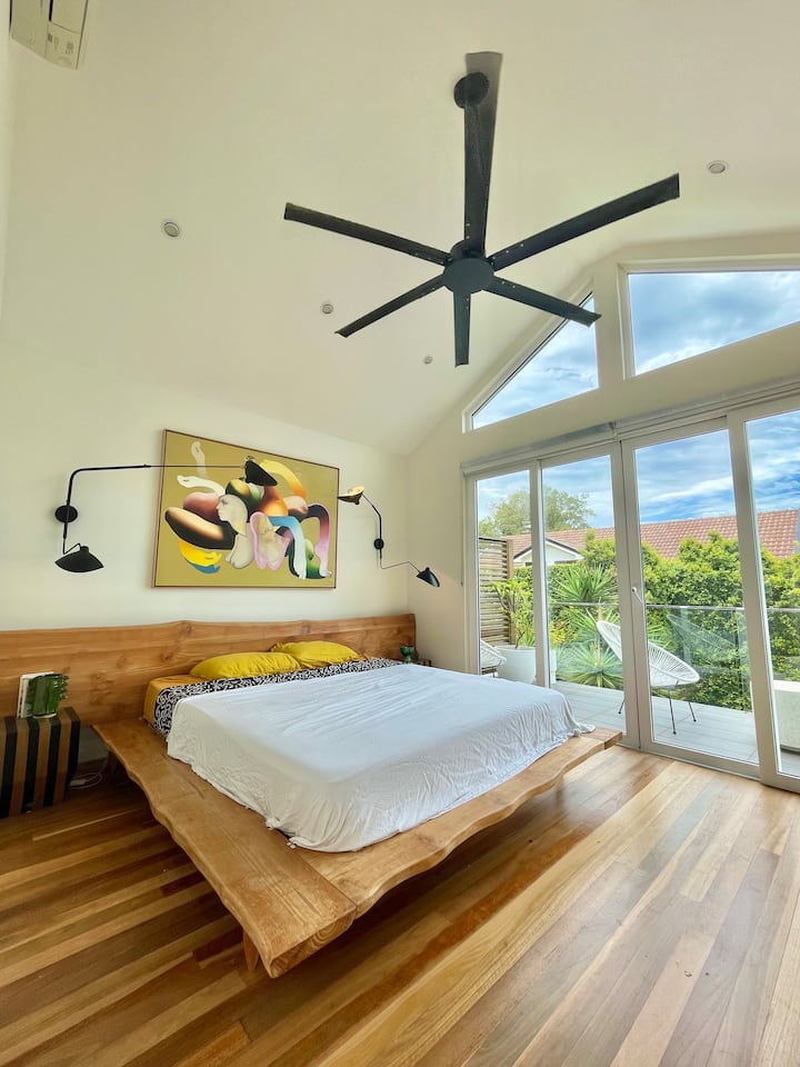 El dormitorio principal tiene un baño privado, un ventilador, aire acondicionado, un amplio balcón con vistas al distrito y un montón de arte increíble de todo el mundo.