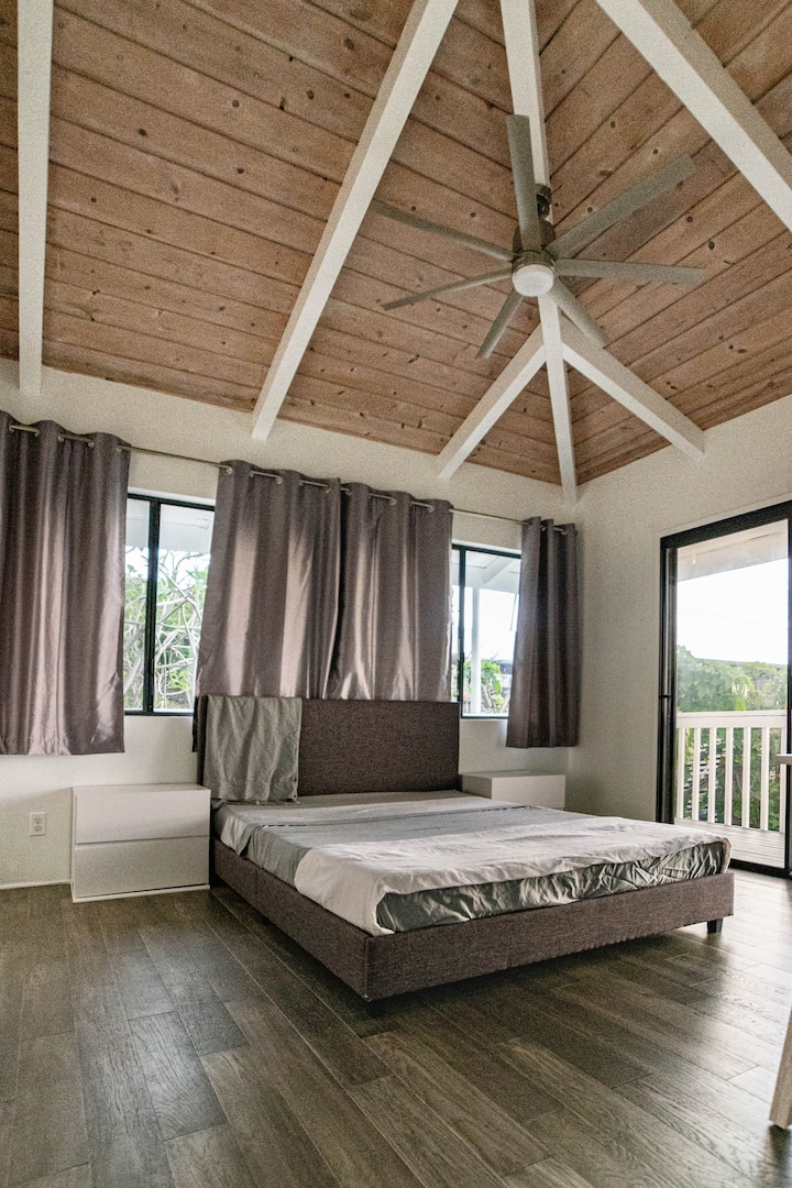 חדר שינה מס '2 מציע את אותה תקרה קמורה גבוהה ומאוורר, אבל עם קצת יותר פרטיות. גוונים שחורים עוזרים לנטרל את האור בבוקר. 