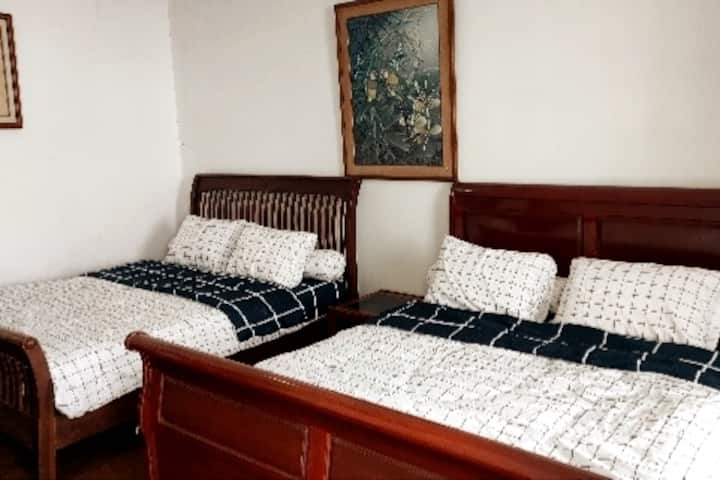 Dormitorio Pabellón 1-B, dos camas tamaño king, con vistas al jardín.