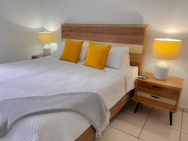 Მყუდრო მთავარი საძინებელი კომფორტული საწოლით, კონდიციონერითა და კედელზე მიმაგრებული ტელევიზორით.