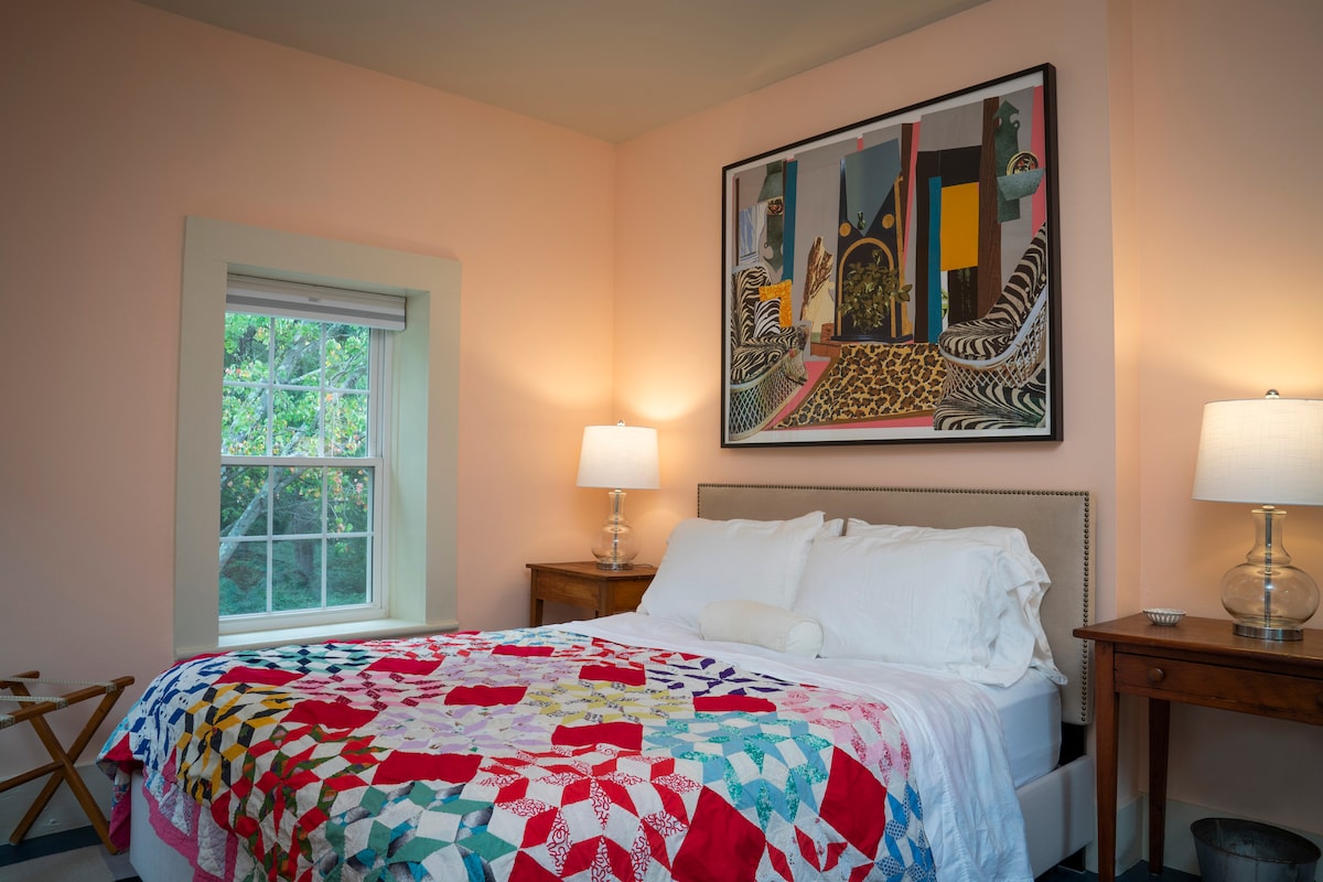 Second floor: comfortable queen bed in a room filled with light and bright art by Mickalene Thomas.