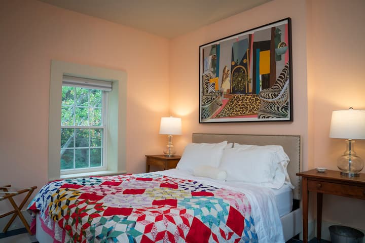 Second floor: comfortable queen bed in a room filled with light and bright art by Mickalene Thomas.