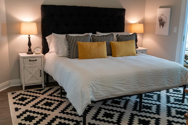 The master bedroom offers a comfortable king bed with cozy bedding and pillows.