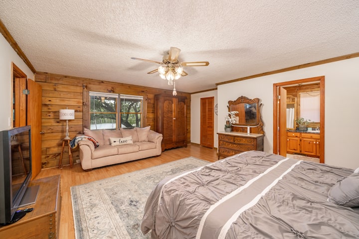 Dormitorio principal con cama tamaño king, sofá cama extraíble y baño principal privado.