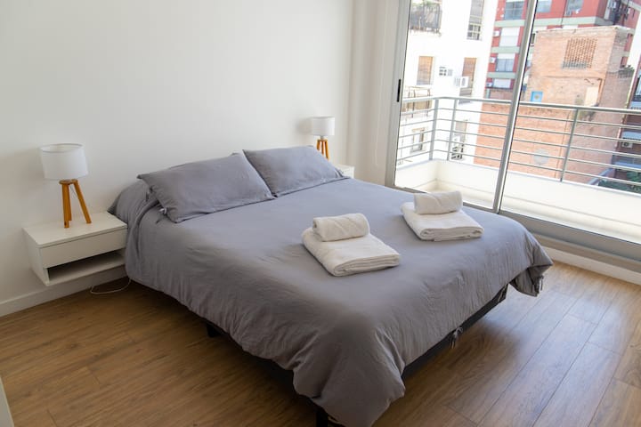 Spavaća soba s bračnim krevetom i drugim svijetlim balkonom. 