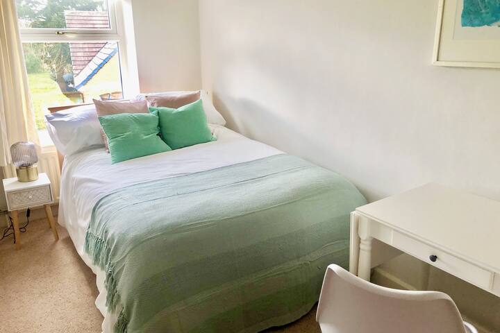 Second bedroom with small double bed, wardrobe, bedside table and desk with lamp