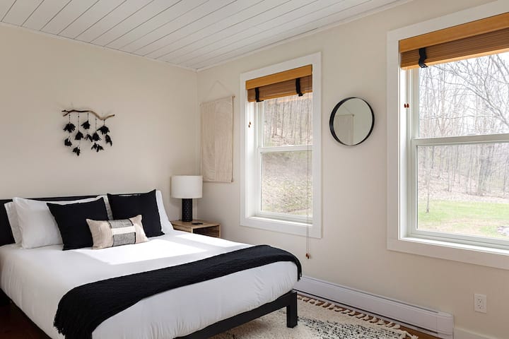Guest room #1 on first floor with queen bed, luggage stand, closet and small dresser.  9 ft by 13 ft.