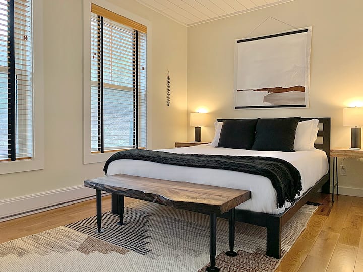 Guest room #2 on first floor with queen bed, luggage stand, closet and small dresser.  9 ft by 13 ft.