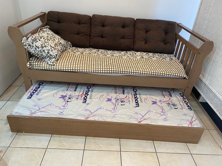يوجد سرير أريكة مع مرتبة عظمية وسرير فردي إضافي