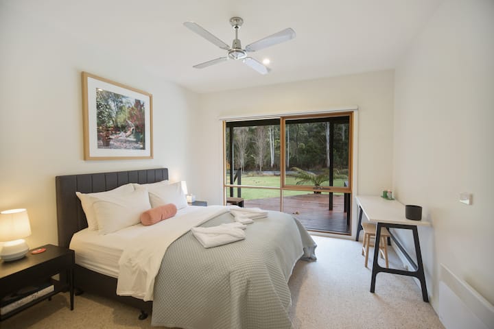 2nd Bedroom with direct view to the Delatite River.  Queensize Bed, desk and velvet ruby bench seat