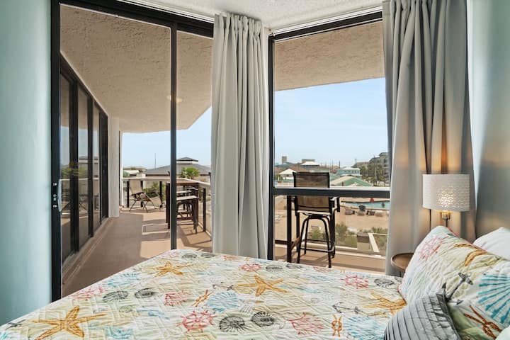 غرفة نوم ثانية مع إمكانية الدخول إلى الشرفة وسرير بحجم كبير.