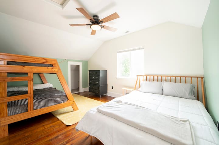 Large upstairs bedroom with Queen bed and Full+Twin bunkbed. Small door in corner is for a bonus/storage closet, but not pictured is a very large walk in closet (right side of photo) with plenty of room for 5 people's clothing needs. See next photo.