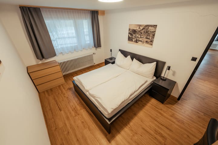 חדר שינה ראשי עם מיטה זוגית, שולחן וארון בגדים