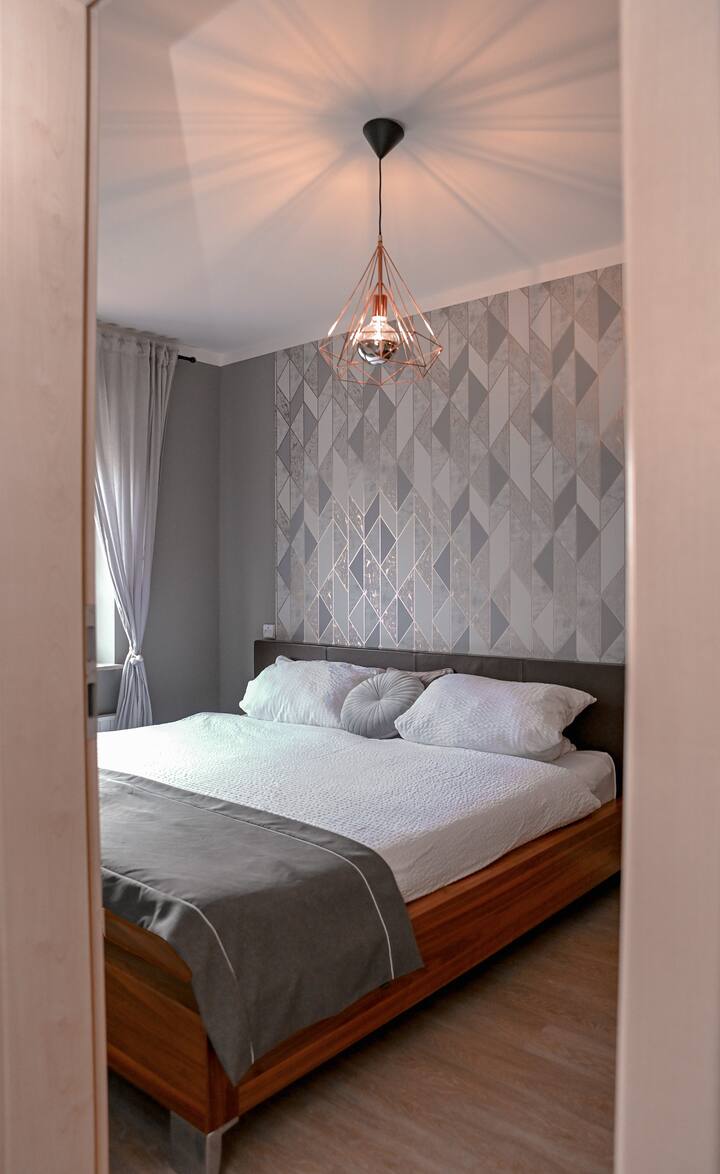 Das schicke Schlafzimmer mit king-size Bett aus edlem Walnussholz und Lederkopfteil.