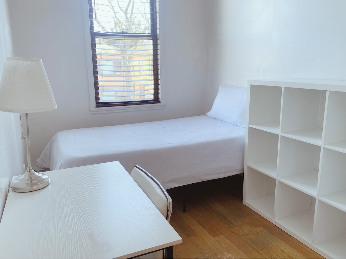 Единично легло с малка маса и стол, идеално за удобна обстановка за работа от дома.