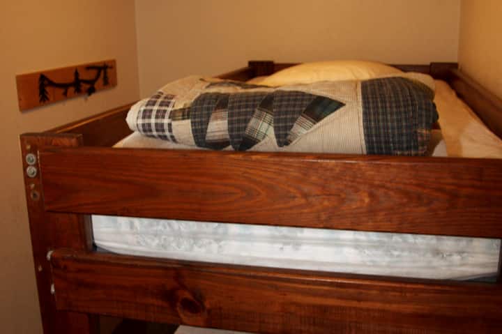 Upstairs bunk room next to bathroom  with a tub.