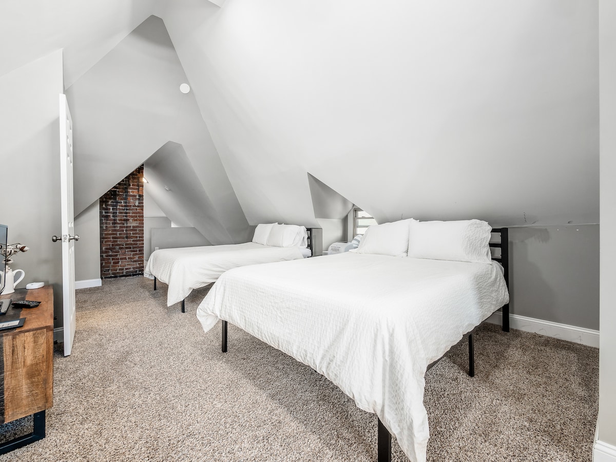 En lugn tillflyktsort med mattor och väggar i neutrala toner, kompletterad med den rustika charmen hos exponerade tegelstenar. Detta mysiga utrymme är utformat för en lugn och vilsam natts sömn.