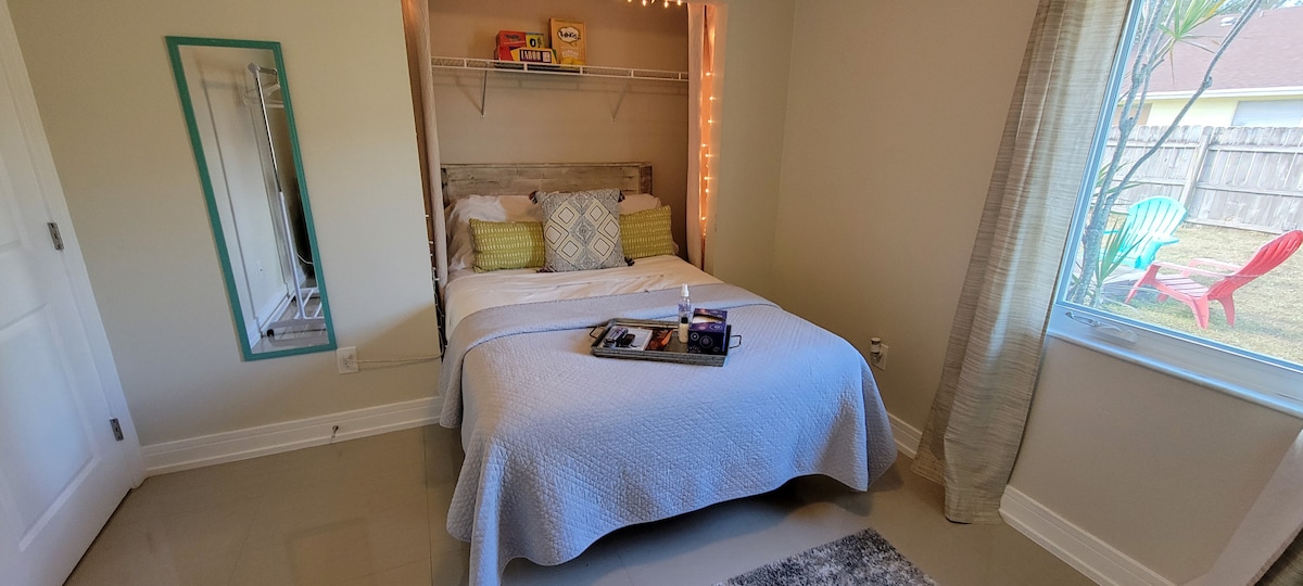 Dormitorio 1: el acogedor rincón de la cama con una ventana con vistas al jardín y el fogón en la parte trasera.