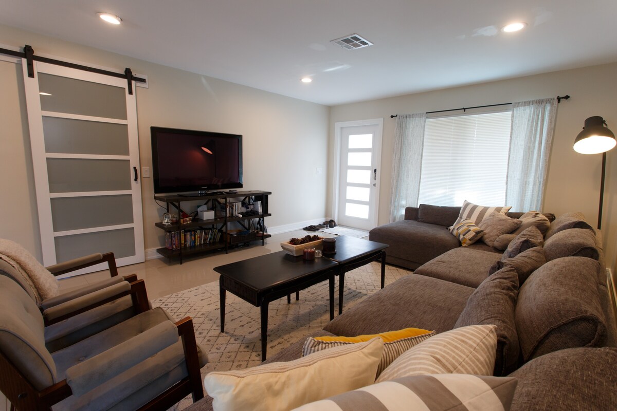 Amplia zona de estar con vista a los jardines delanteros y traseros en la sala de estar común.