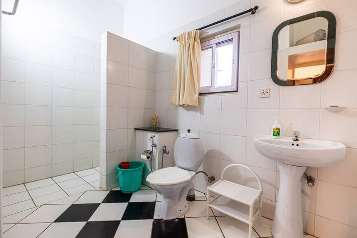 The bathroom is equipped with modern fixtures, including a shower, a sink, and a toilet. Hot water is available in all bathrooms, ensuring a relaxing and refreshing bathing experience.