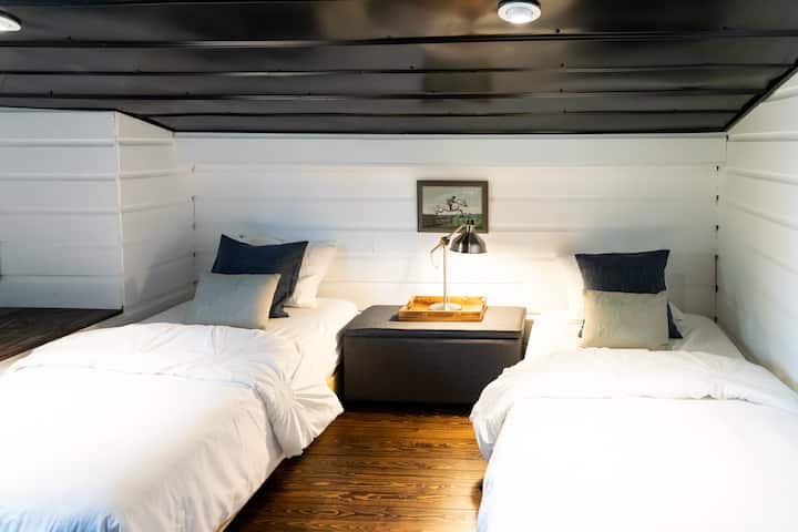 מיטות זוגיות - גובה התקרה מגיע לקו הגג והוא נמוך בצד אחד של החדר הזה.