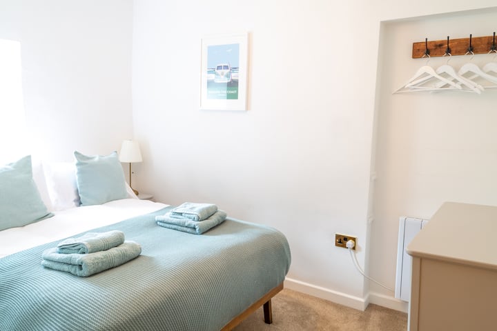 غرفة نوم مزدوجة مريحة مع أغطية ومناشف ذات جودة فندقية.