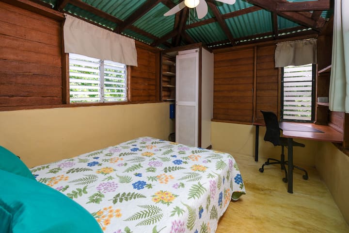The bedroom holds a double bed. It has a work station desk.