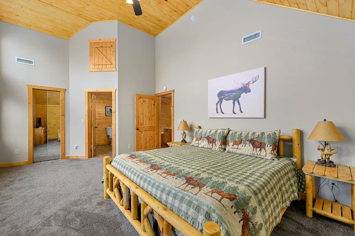 Enjoy this huge master bedroom with hand carved custom log wood king bed, 40" HD TV, knotty pine wood ceiling and walk in closet. 