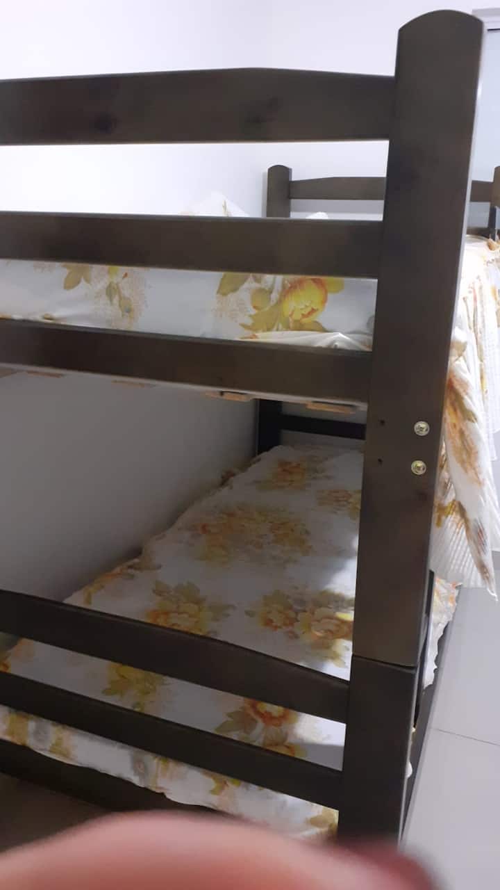 Habitación con 2 literas, ventilador de techo y aire acondicionado.