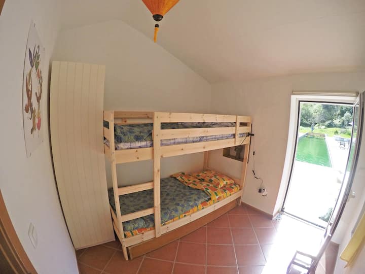 ห้องนอนที่ 2 มีเตียงสองชั้นและลิ้นชักนำไปสู่ลานด้านบนและมองเห็นสระว่ายน้ำชีวภาพ