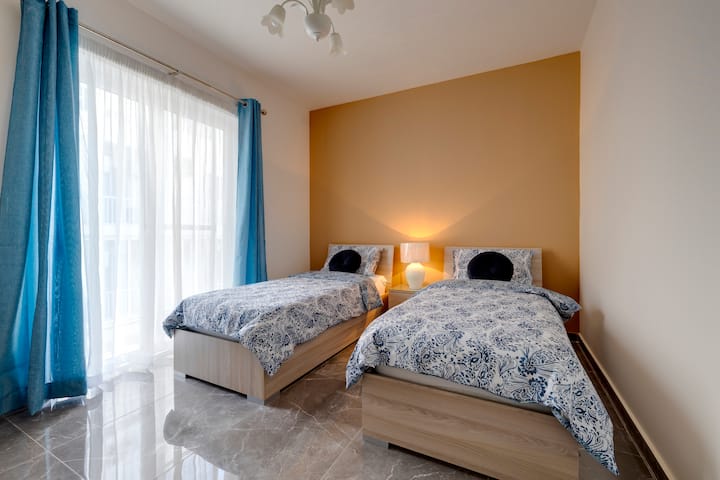 غرفة نوم فردية بسريرين وشرفة.