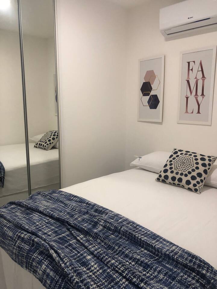 חדר שינה שני עם מיטה זוגית, מיזוג אוויר מפוצל וארונות בגדים.