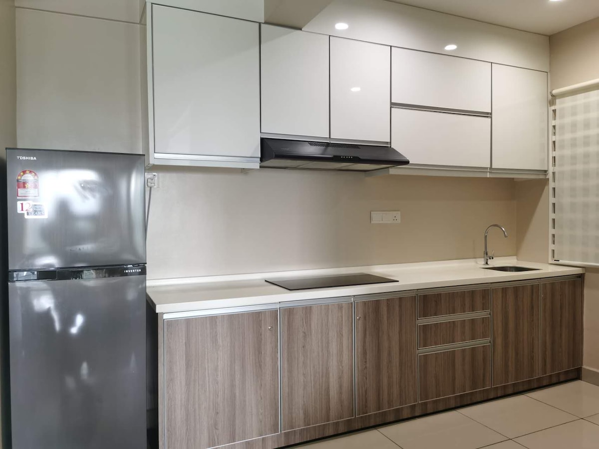 A modern kitchen is presented with sleek, white upper cabinets and wooden lower cabinets. A stainless steel refrigerator is included, alongside a contemporary range hood above the stove area. An under-mounted sink is installed with a minimalist faucet, all complemented by clean white countertops.