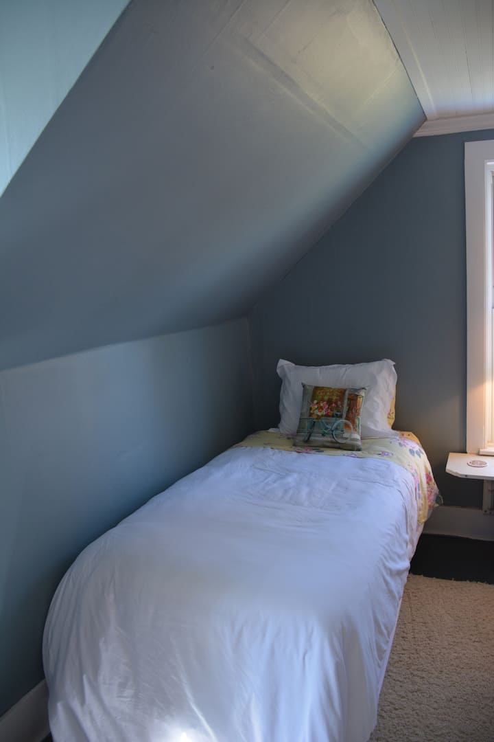 Single bed with lamp and chair
