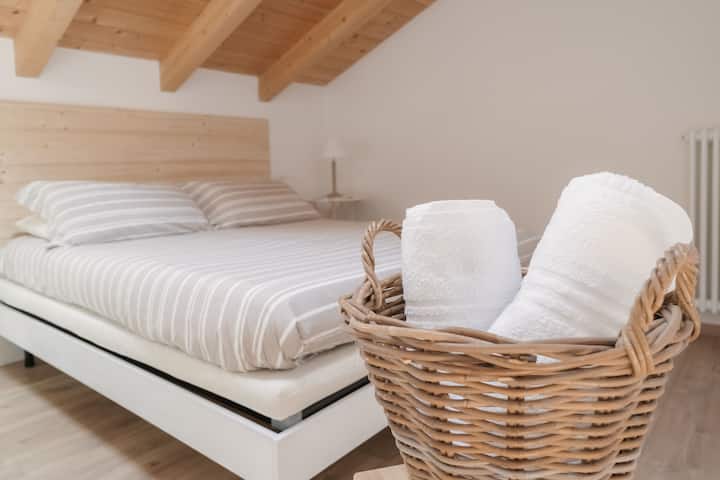 Intímna a svetlá izba s odkrytými trámami a prírodnými tónmi, kde každé prebudenie je momentom pokoja a harmónie.