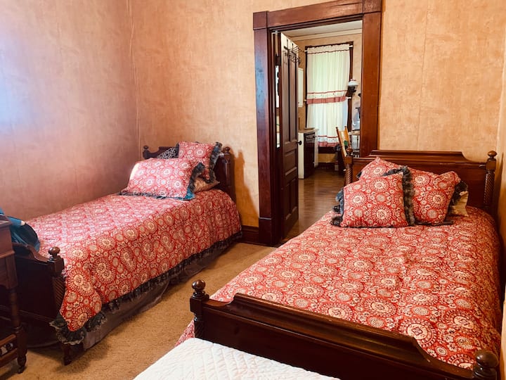 تتميز غرفة النوم هذه بسريرين صغيرين ومكتب للكتابة.