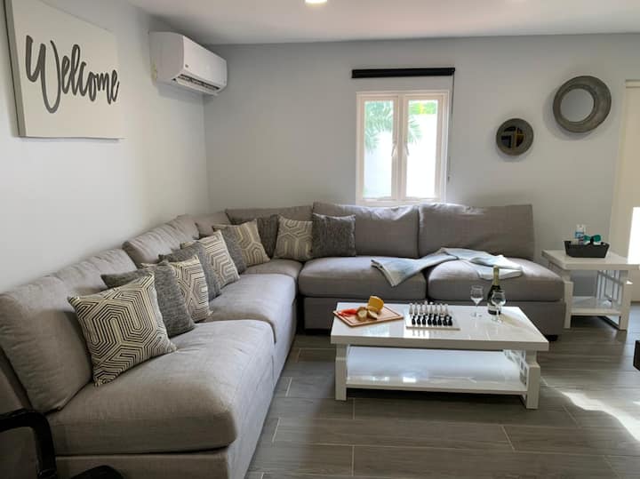 Sala de estar con un sofá modular, una mesa de café y un televisor inteligente. 