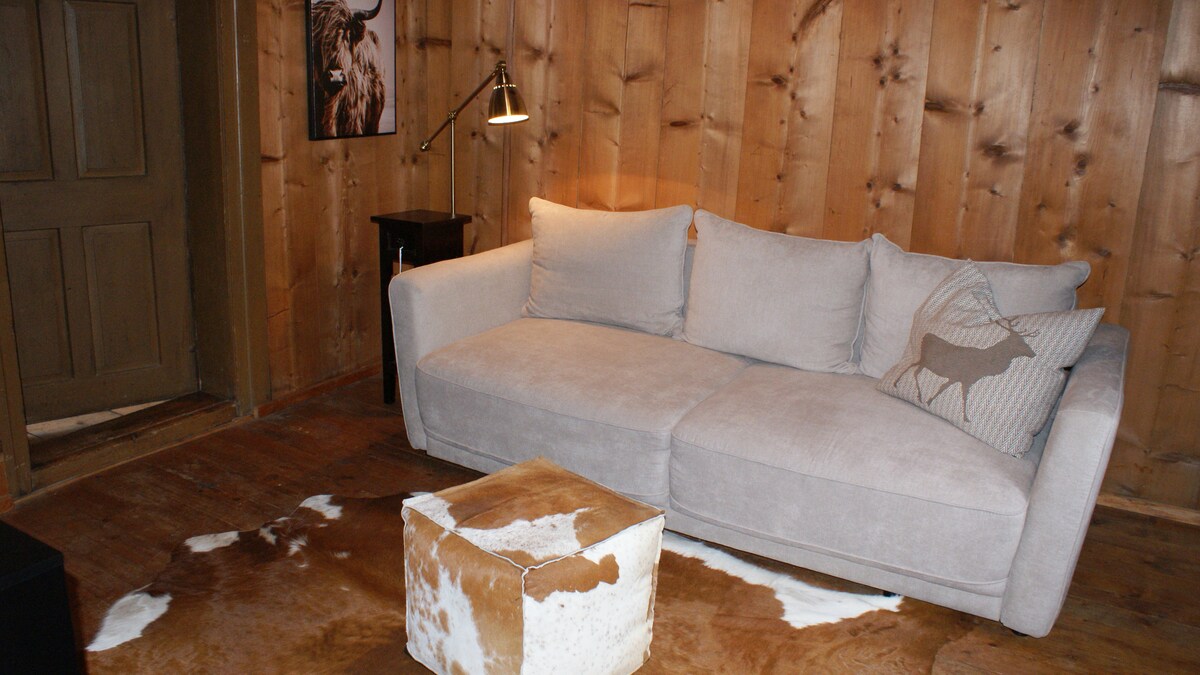 ТВ стая с разтегателен диван до 140 см, коридор към стая с две единични легла с изглед към склона, ливадите и Валсеркам.